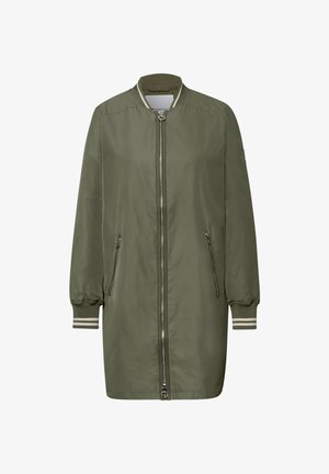 Długa oliwkowozielona kurtka typu bomber z przednim zamkiem błyskawicznym, zapinanymi na zamek kieszeniami bocznymi, ściągaczem przy kołnierzu i mankietami z białymi paskami.