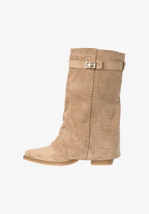 Beżowy zamszowy but do połowy łydki z perforowanym wzorem, niskim obcasem w kształcie słupka, spiczastym noskiem oraz ozdobnym paskiem z klamrą w złotym odcieniu.