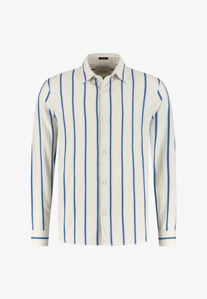 Skjorte med knapper i hvit med blå vertikale striper. Har buet kant, lange ermer og subtilt strukturert stoff. Knapplukking foran.