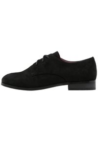 Chaussure à lacets en suede noir avec un bout arrondi, des détails de couture subtils et un talon bas et plat. Texture lisse avec un design minimaliste.