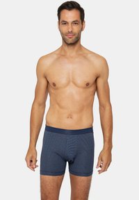 Laivastonsiniset boksershortsit, joissa on ribbineulottu rakenne, joustava vyötärönauha ja istuva muotoilu; niissä on hienovarainen raidallinen kuvio.