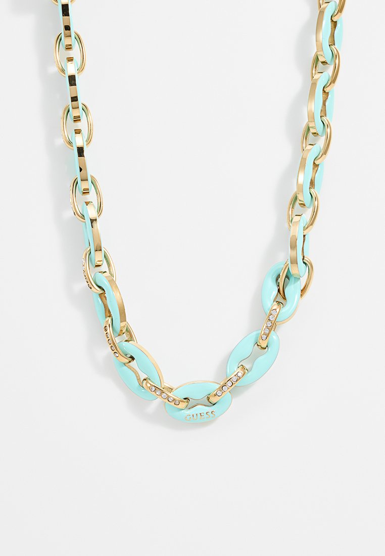 Kette aus vergoldetem Metall mit abwechselnden hellblauen emaillierten ovalen Gliedern und kleinen Kristallakzenten, versehen mit einem "GUESS"-Logo.