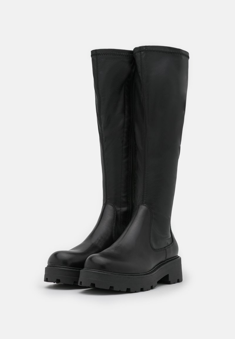 Bottes noires en cuir, jusqu'aux genoux, avec une surface lisse, une semelle en caoutchouc épaisse et une fermeture éclair sur le côté pour un enfilage facile. Design minimaliste, sans accents visibles.