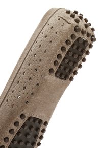 Bruine suède schoen met geperforeerde bovenkant, rubberen zool met verhoogde ronde noppen voor grip en textuur. Eenvoudig ontwerp, instapstijl.