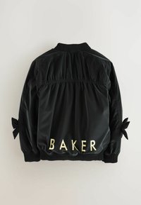 Giacca bomber nera in nylon con retro arricciato, polsini a coste e lacci sulle maniche. Scritta "BAKER" in lettere dorate sul retro.