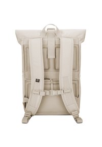 Sac à dos beige à rabat avec dos en mesh rembourré, bretelles réglables et plusieurs boucles. Comprend une poignée supérieure et un design minimaliste.
