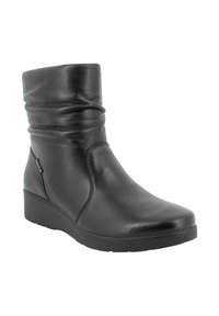 Stivale alla caviglia in pelle nera con un gambale morbido, punta tonda e tacco a zeppa. Texture liscia con cuciture minime e un sottile dettaglio con zip laterale.