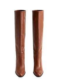 Bottes en cuir marron au-dessus du genou avec une texture lisse, un bout carré et une coupe ajustée. Aucun élément métallique ni ornement visible.