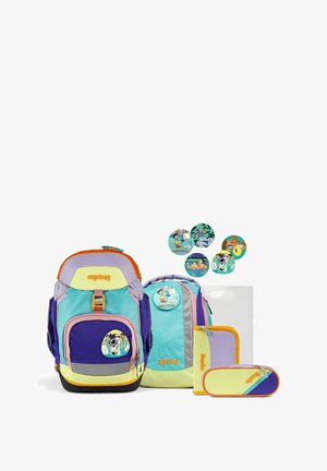 Mehrfarbiger Rucksack, hauptsächlich blau und grün, mit orangefarbenen Akzenten und Cartoon-Aufnähern. Enthält auch eine Federtasche und runde Aufkleber.