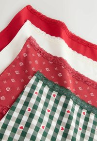 Vier Stoffstücke: lebhaftes Rot, Weiß und grüne Muster, mit Spitzenbesätzen, Schneeflockendrucken und karierten Designs mit Herzen.