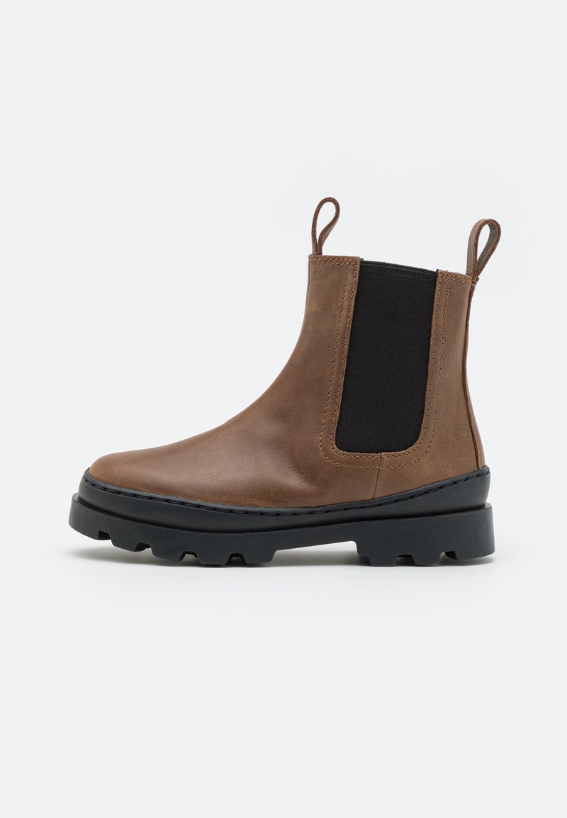 Bottines Chelsea en cuir marron avec panneaux élastiques noirs sur les côtés, bout arrondi et semelle en caoutchouc noir épaisse dotée de détails de traction.