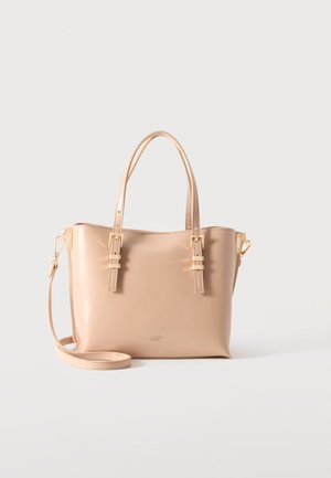 Bolso tote de cuero beige con doble asa, correa de hombro desmontable y detalles de hebillas doradas sobre un fondo claro y liso.