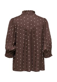 Blouse marron à pois blancs, empiècement froncé au dos, manches 3/4 bouffantes avec poignets smockés et petit col volanté.