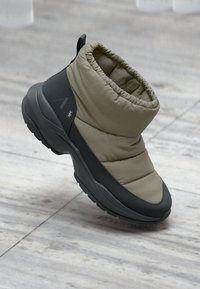 Leichtgewichtiger Knöchelboot in Olivgrün und Dunkelgrau, mit einem gesteppten Obermaterial, gepolstertem Kragen und strukturiertem Sohle für besseren Halt.