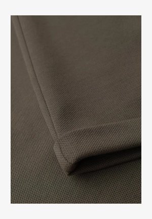 Tela marrón texturizada con un patrón sutil, doblada de manera ordenada en el borde. Superficie suave con un caído delicado y detalles de costura reforzados.