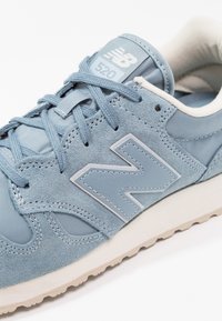 Jasnoniebieskie sneakersy wykonane z zamszu i siateczki, z skórzanymi akcentami, dużym logo "N", okrągłymi sznurowadłami i teksturowaną białą podeszwą.