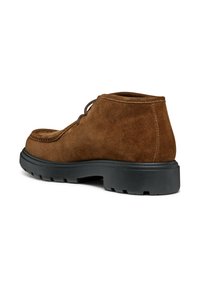 Stivaletti alla caviglia in suede marrone con finitura testurizzata, dotati di una spessa suola in gomma nera e punta arrotondata, chiusura con lacci e cuciture resistenti.