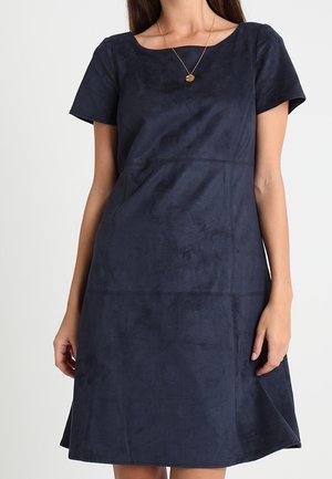 Marineblå kortærmet kjole med en afslappet pasform, glat suede-lignende tekstur og paneldetaljer. Har en rund udskæring og en svajet nederdel.