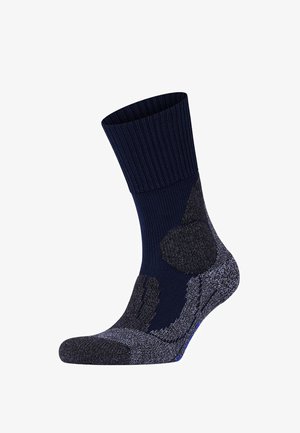 Calza blu navy con risvolto a coste, punta e tallone rinforzati, e accenti grigi texturizzati. Presenta una miscela di materiali per garantire durata.