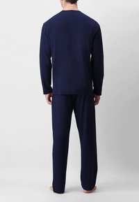 Maglietta a maniche lunghe blu navy e pantaloni abbinati, realizzati in un materiale morbido, caratterizzati da un taglio semplice senza loghi o motivi visibili.