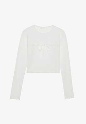 Biały, długi rękaw, krótki top z prążkowanej tkaniny, z okrągłym dekoltem i dekoracyjnym wiązaniem oraz falbaniastym dołem. Prosty i dopasowany fason.