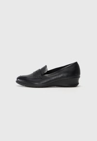 Black leather wedge loafers with a rounded toe and decorative stitched accents on the vamp. Smooth texture, low wedge sole design.