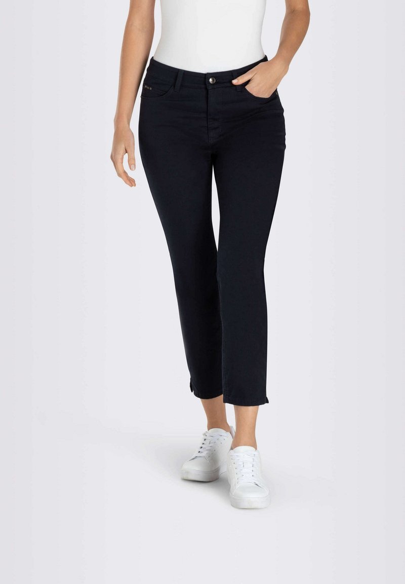Jean skinny bleu marine avec une taille mi-haute, doté d'une fermeture à bouton avant, de cinq poches et de détails à l'ourlet brut au niveau des chevilles.