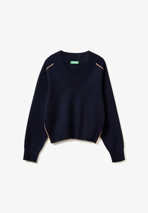 Granatowy sweter z dzianiny o dekolcie w serek, z opadającymi ramionami i ściągaczami na mankietach. Posiada subtelne pomarańczowe lamówki wzdłuż bocznych szwów. Krótkiej długości.