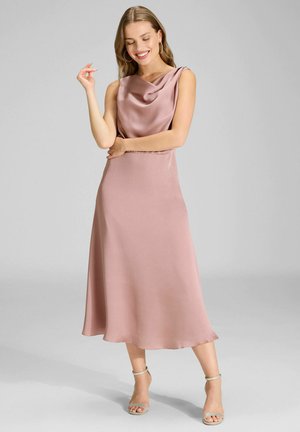 Rosa Satinkleid mit Wasserfallausschnitt und ausgestelltem Saum. Glatte Textur und ärmelloses Design. Kombiniert mit silbernen Absatzschuhen mit Knöchelriemen.