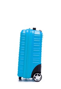 Tvrdý kufr v jasně modré barvě, s texturovanými pruhy, černým základem a stříbrným designem koleček. Hladké zapínání na zip na vrchu.