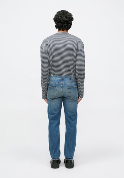 Πουκάμισο με μακριά μανίκια και ρίγες σε γκρι και λευκό χρώμα, σε συνδυασμό με μπλε τζιν. Casual εφαρμογή με ίσιο πόδι και απλές πίσω τσέπες. Μαύρα παπούτσια.