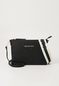 Black Valentino crossbody bag with embossed logo pattern, gold-tone brand name, and detachable white and black wide strap on white background.