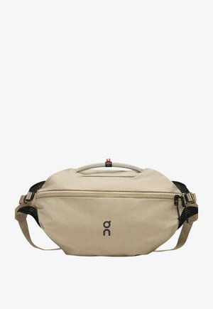 Beige heuptasje met een voorsluiting, verstelbare banden, zwarte mesh zijkanten, een touwhandvat met het label "Swiss Seil" en een "on" logo middenvoor.
