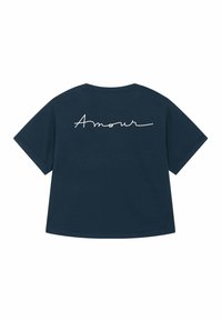 Jūras spēku t krekls ar īsām piedurknēm, kuram mugurpuses ir balti kursīvas burti, kas saka "Amour".