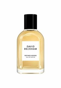 Läpinäkyvä lasipullo pyöreällä muotoilulla, mustalla kannella ja valkoisella etiketillä. Sisältää keltaista nestettä, jonka etiketti on "Refined Woods Eau de Parfum."