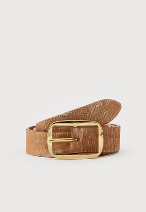Ceinture en cuir grainé couleur beige avec boucle métal rectangulaire dorée, roulée et posée sur fond blanc.