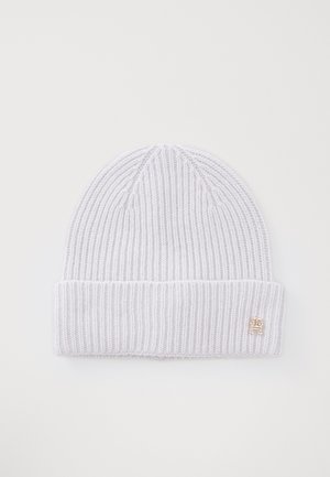 Un bonnet en tricot côtelé gris clair avec un revers et un petit accent de logo doré. Texture douce et design ajusté.
