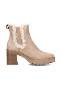 Stivaletto in suede beige con un robusto tacco a blocco, rifiniture in pelliccia, pannelli laterali elasticizzati e suola in gomma testurizzata per una migliore aderenza.