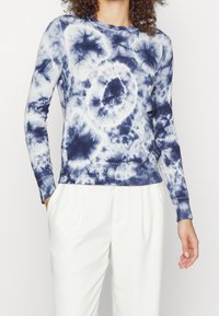 Marinblå och vit tie-dye tröja med lång ärm, ribbade muddar och fåll, med rund halsringning och mjukt, texturerat tyg.