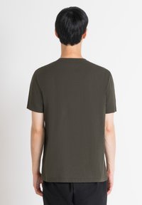 Camiseta de manga corta color verde olivo hecha de algodón suave, con cuello redondo y corte recto sin patrones ni gráficos visibles.
