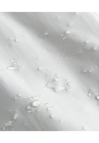 Waterafstotende witte stof met zichtbare druppels, een gladde textuur en een lichte glans, wat zorgt voor een overall schone en minimalistische uitstraling.
