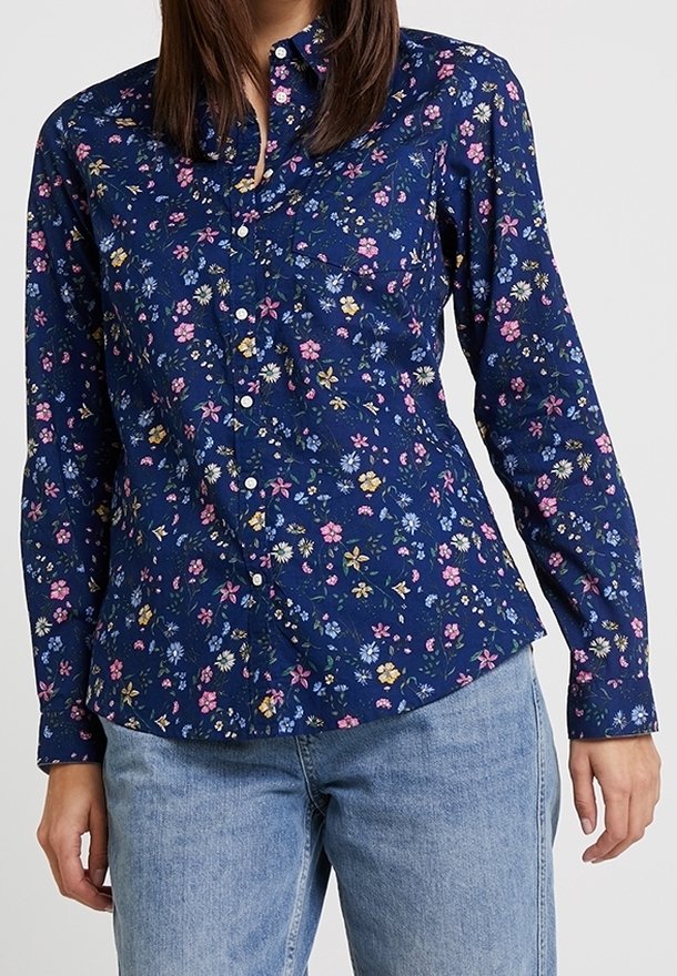 Navy button-up shirt featuring a floral pattern in pink, yellow, and blue. Long sleeves with a fitted design; cotton material.