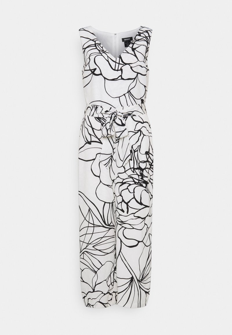 Combinaison blanche sans manches avec jambes larges, grand imprimé floral noir, col en V et ceinture nouée à la taille, présentée sur fond gris.