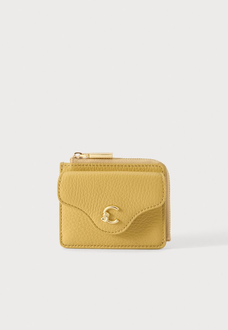 Portefeuille en cuir jaune texturé avec une poche avant à rabat et une fermeture éclair dorée sur le dessus, sur un fond clair uni.