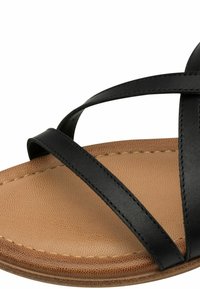 Mustad mustandiga mustad faux nahast sandaalid risti rihmadega, lamedatel tan värvi talladel ja tekstureeritud sisetallaga. Puhtad jooned minimaalsete riistvarade aktsentidega.