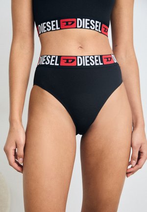 Mutande in cotone nere a vita alta con una fascia in rosso e bianco con il logo "DIESEL" e una texture liscia, caratterizzate da un design classico e minimalista.