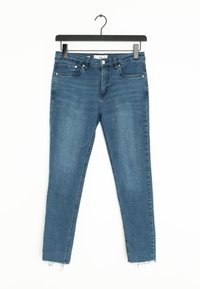 Jeans de mezclilla azul con un ajuste slim, que presentan un dobladillo recortado y un ligero deshilachado en la parte inferior. Diseño de cinco bolsillos con cierre de botón en la parte delantera.