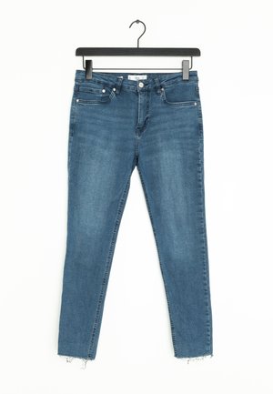 Niebieskie dżinsy o slim fit, z cropped hem i delikatnym przetarciem na dole. Pięć kieszeni i zapięcie na guzik z przodu.