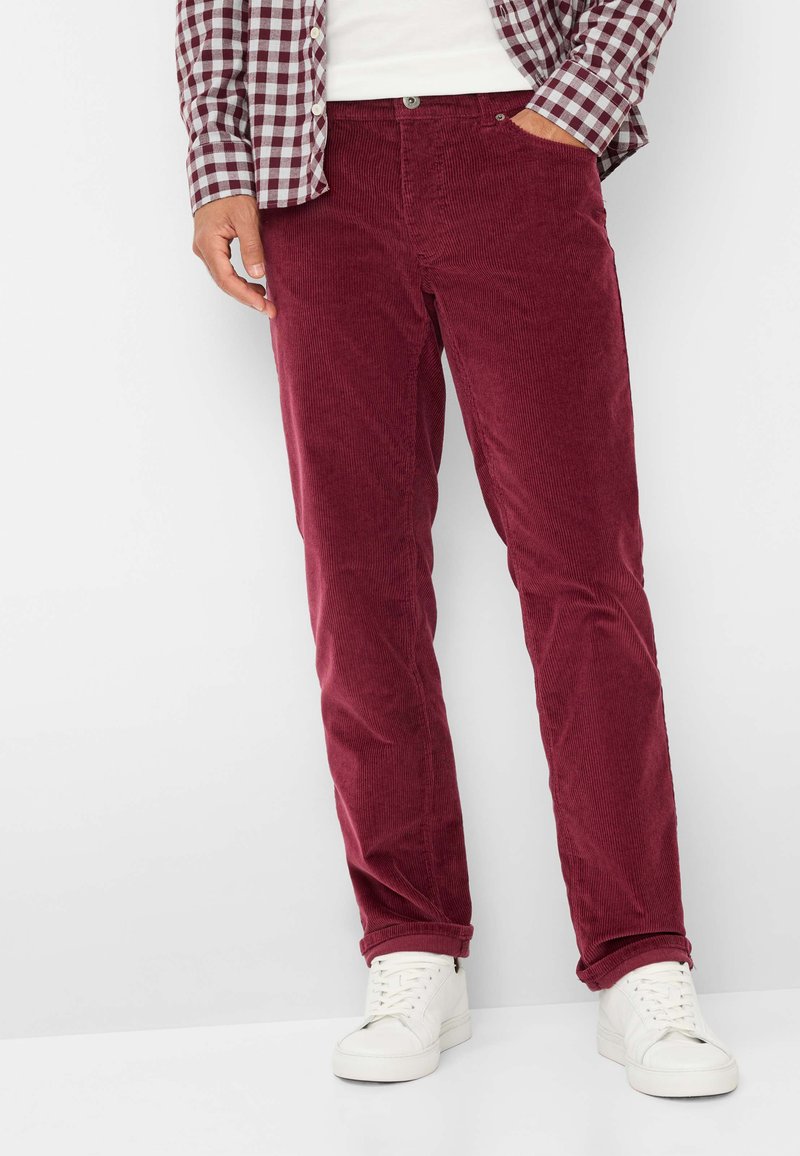 Bordeaux corduroy broek met een recht model, gekenmerkt door een opvallende ribbelstructuur, standaard voorzakken en gecombineerd met witte sneakers.