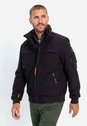 Schwarze isolierte Jacke mit Reißverschluss, hohem Kragen und mehreren Taschen. Verfügt über gerippte Bündchen und ein kontrastierendes Futter.